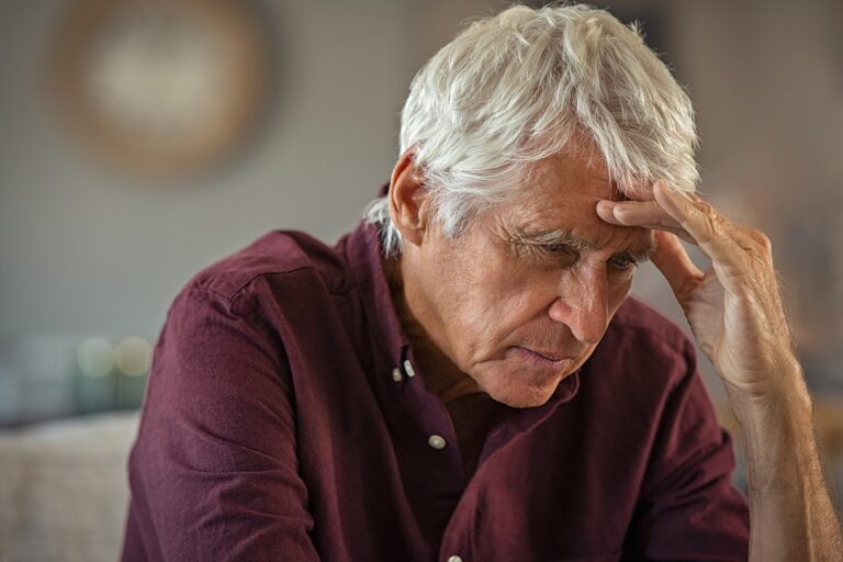 Stressed Man With Hand On Forehead
