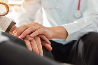 Close Up Of Hands Doctor Reassuring His Patient